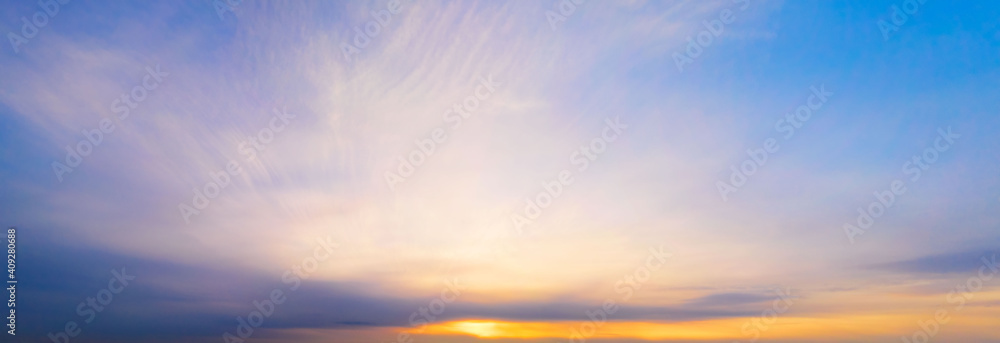 Panoramic purple sky with yellow Winter sun and Stratocumulus clouds. A panorama of the cold blue sunset sky.