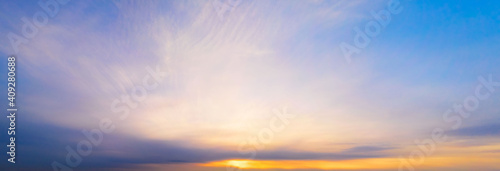 Panoramic purple sky with yellow Winter sun and Stratocumulus clouds. A panorama of the cold blue sunset sky.