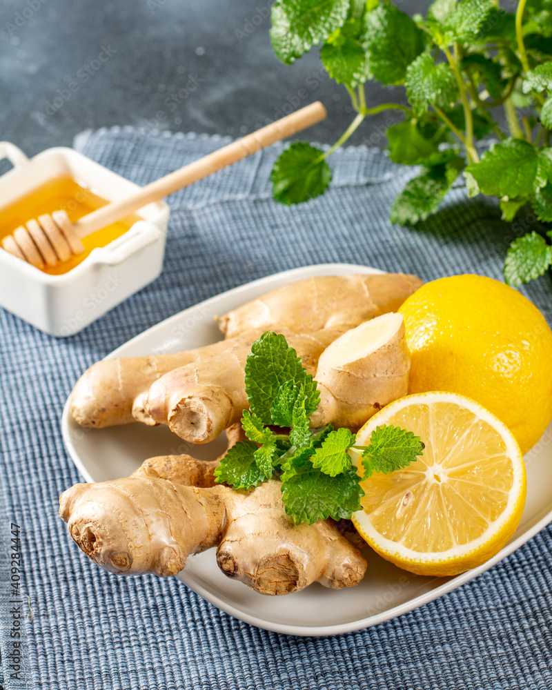 Ingredients for ginger tea with lemon, honey and mint. Lemon, ginger, honey and mint on the kitchen table. Healthy food for the immune system. Closeup