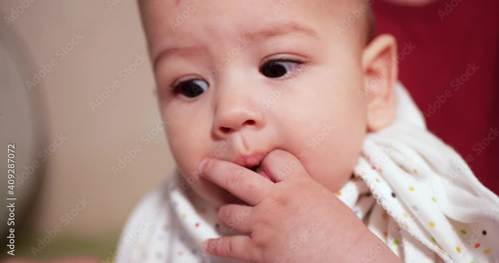 mother holds the baby in her arms and feeds her boy with a spoon. family, food, child, eating and parenthood concept mother holds the baby in her arms and feeds her boy with a spoon. family, food, child, eating and parenthood concept