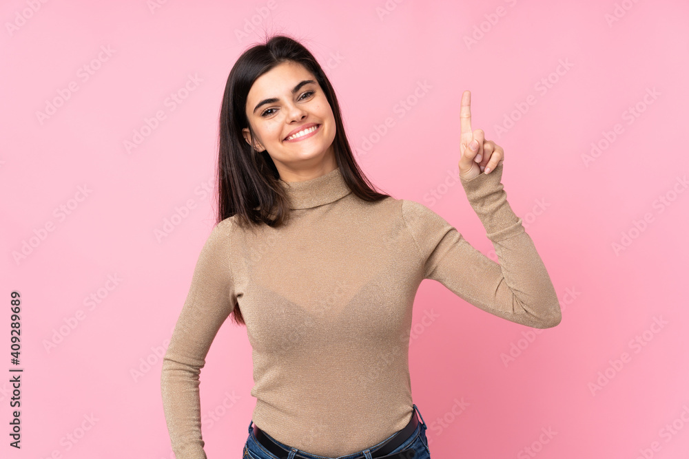 Young woman over isolated pink background showing and lifting a finger in sign of the best - obrazy, fototapety, plakaty 