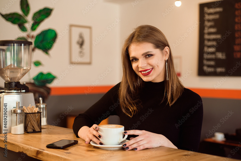 Portrait of young woman drinking coffee in cafe. Portrait of young woman drinking coffee in cafe.