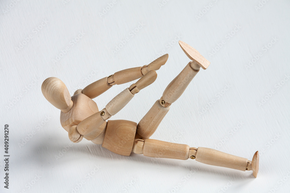 a wooden mannequin doing exercises on white background