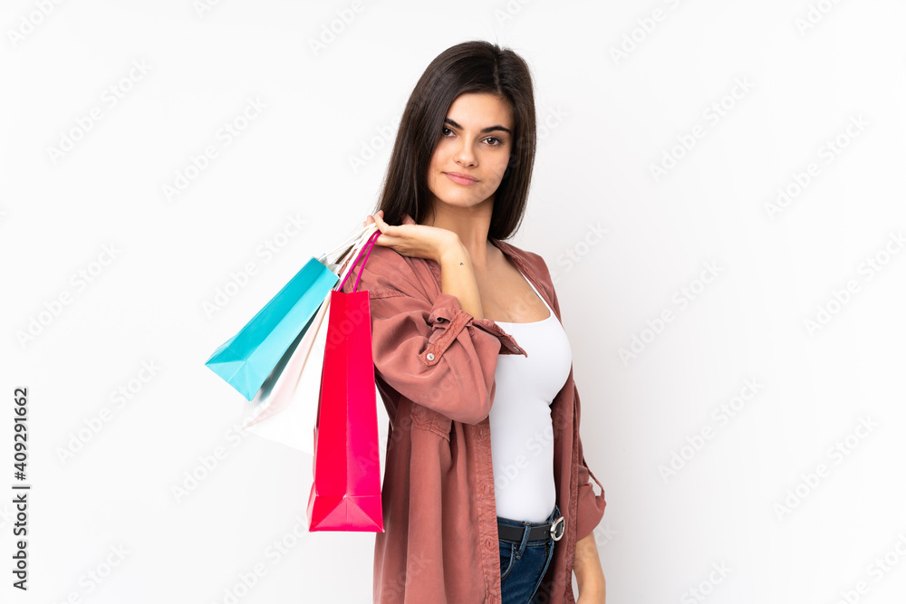 Young woman over isolated white background holding shopping bags