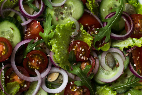 vegetable vegetrian salad in a white plate on a wooden table in the kitchen photo