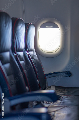 One row of 3 empty black seats inside plane.