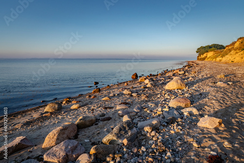 Steiniger Strand vor der Steilküste bei Klein-Waabs bei Eckernförde in Schleswig-Holstein im Morgenlicht. photo