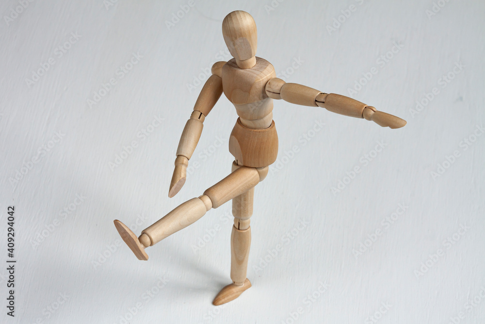 a wooden mannequin doing exercises on white background a wooden mannequin doing exercises on white background