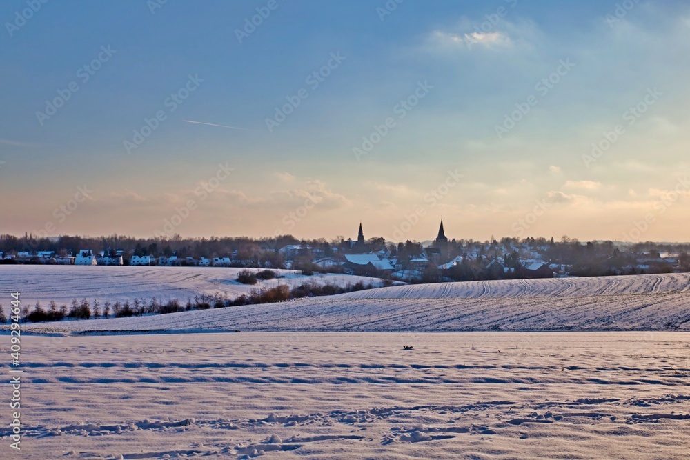 the catholic and protestant church of homberg in winter with snow and blue sky	
