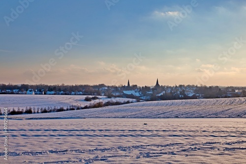 the catholic and protestant church of homberg in winter with snow and blue sky 