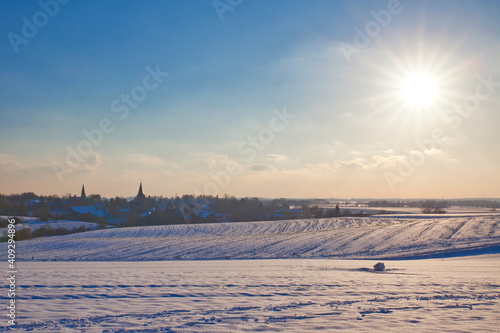 the catholic and protestant church of homberg in winter with snow and blue sky and sun  © mschauer