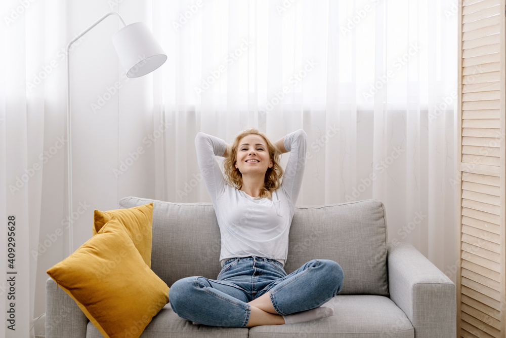 Woman crossing hands behind head, resting at home Woman crossing hands behind head, resting at home