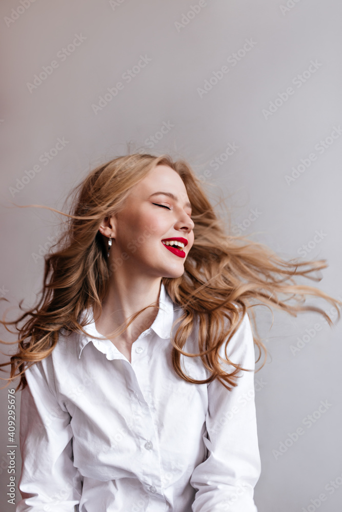 Inspired blonde woman posing with closed eyes. Studio shot of relaxed girl in white shirt. Inspired blonde woman posing with closed eyes. Studio shot of relaxed girl in white shirt.