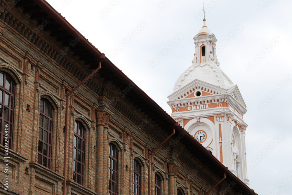 Ancient colonial palace with the bell tower of the San Francisco of Cuenca behind it