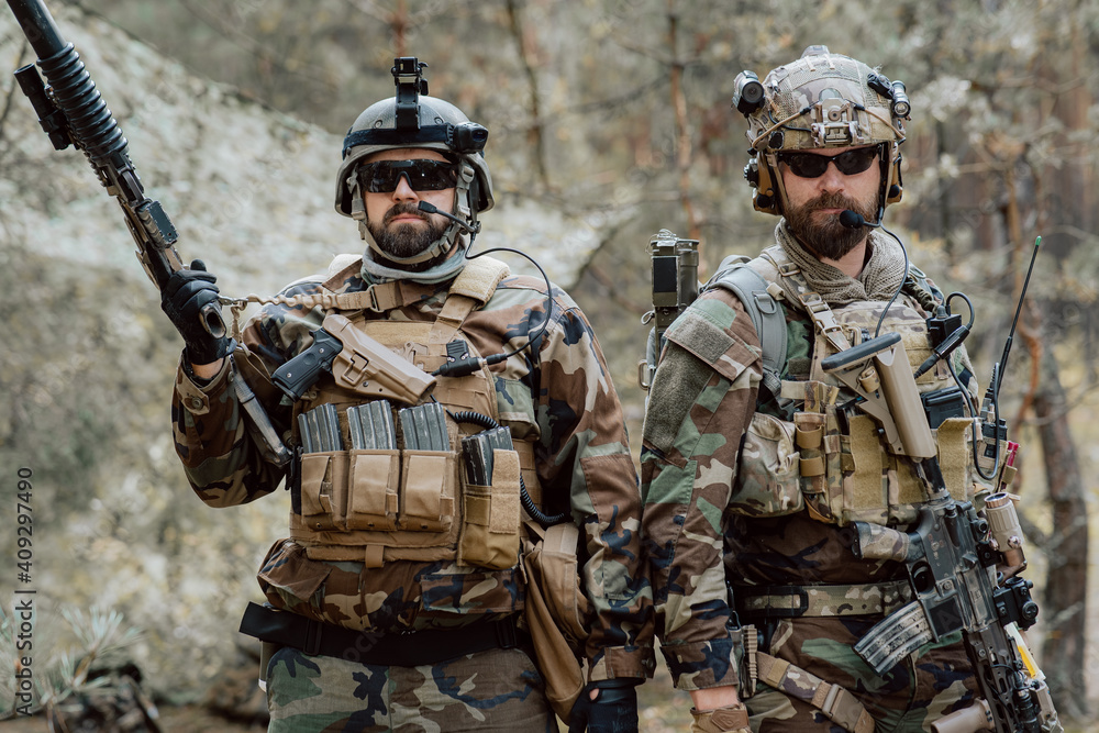 Portrait of a middle-aged bearded soldiers in a Woodland military uniform  and helmet, with headphones on his head holding a rifle. Stock Photo |  Adobe Stock