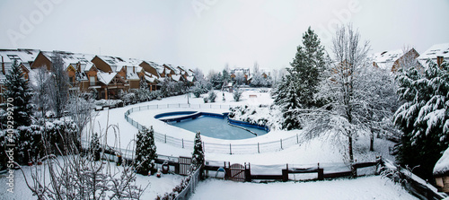 Snow covered yard with a pool in a beautiful neighborhood in Bucharest. Christmas background. Cold temperature, winter time
