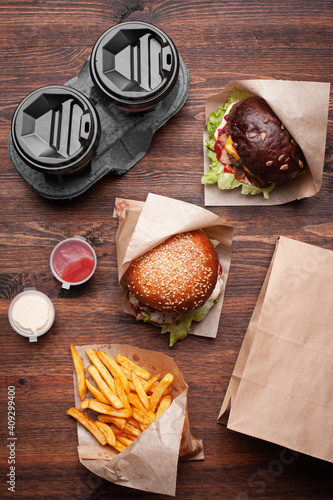 Burgers with french fries on wooden table top view