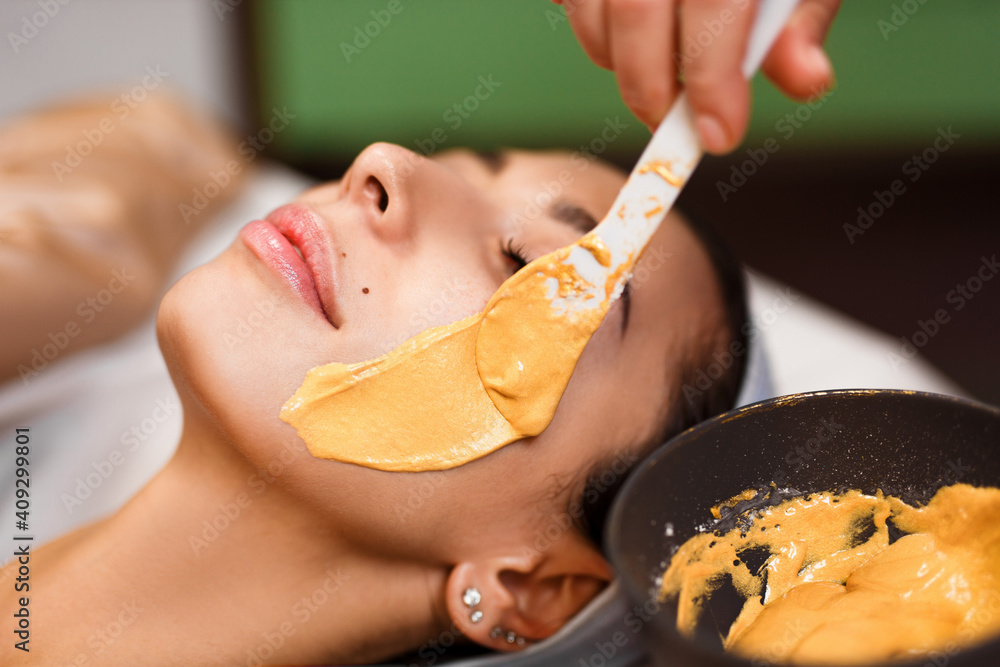Procedure for skin care. Doctor in cosmetology office applies an yellow