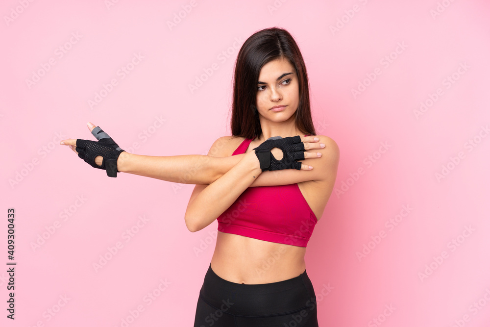 Young sport woman over isolated pink background stretching arm Young sport woman over isolated pink background stretching arm