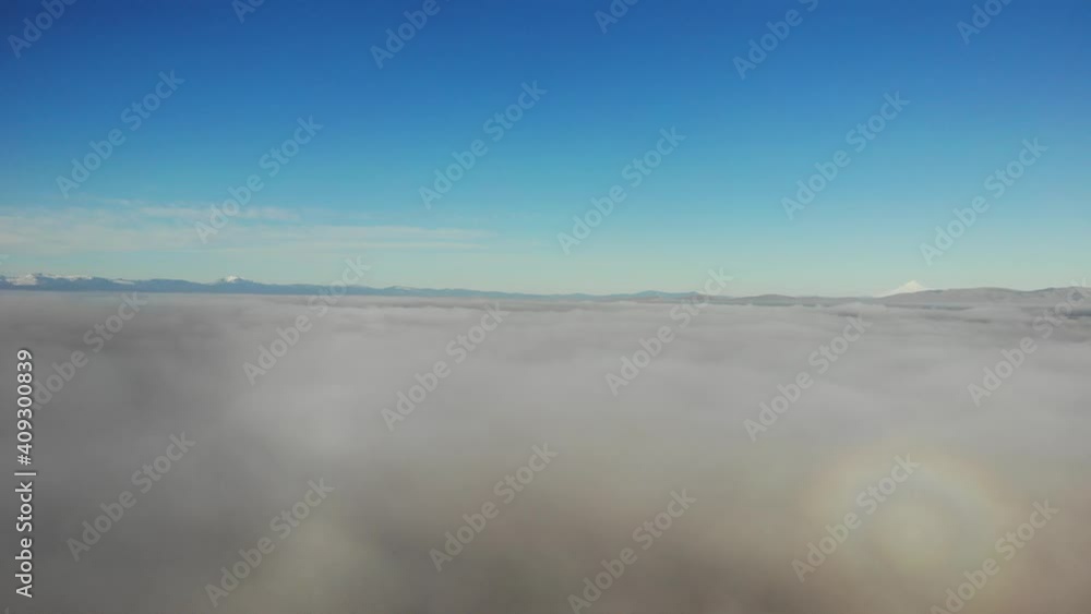 Drone video Rolling cloud bank in foreground with tiny mountains in the distance Drone video Rolling cloud bank in foreground with tiny mountains in the distance