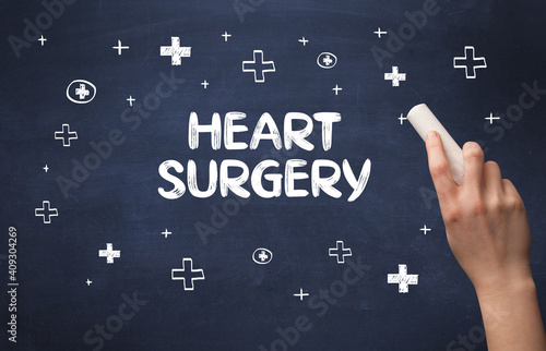 Hand drawing HEART SURGERY inscription with white chalk on blackboard, medical concept