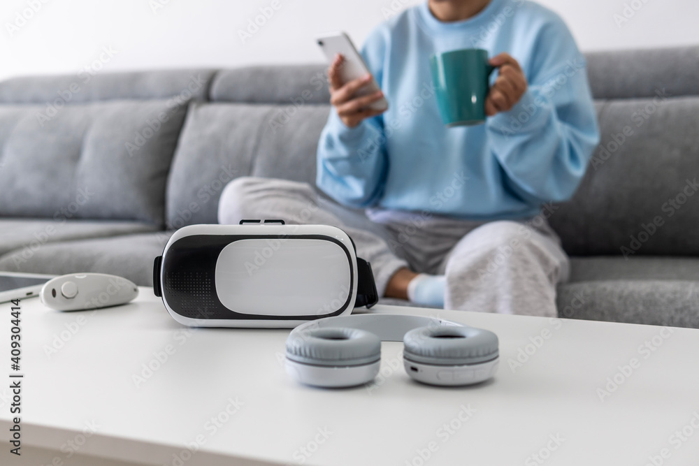 Headphones and virtual reality glasses and in the background a pretty girl with a cup and a mobile Headphones and virtual reality glasses and in the background a pretty girl with a cup and a mobile