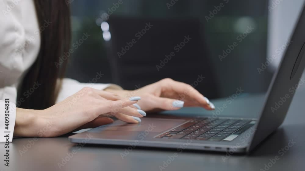 Female hands with manicure typing on laptop and touching touchpad. Partial view of businesswoman working in office. Concept of job Female hands with manicure typing on laptop and touching touchpad. Partial view of businesswoman working in office. Concept of job