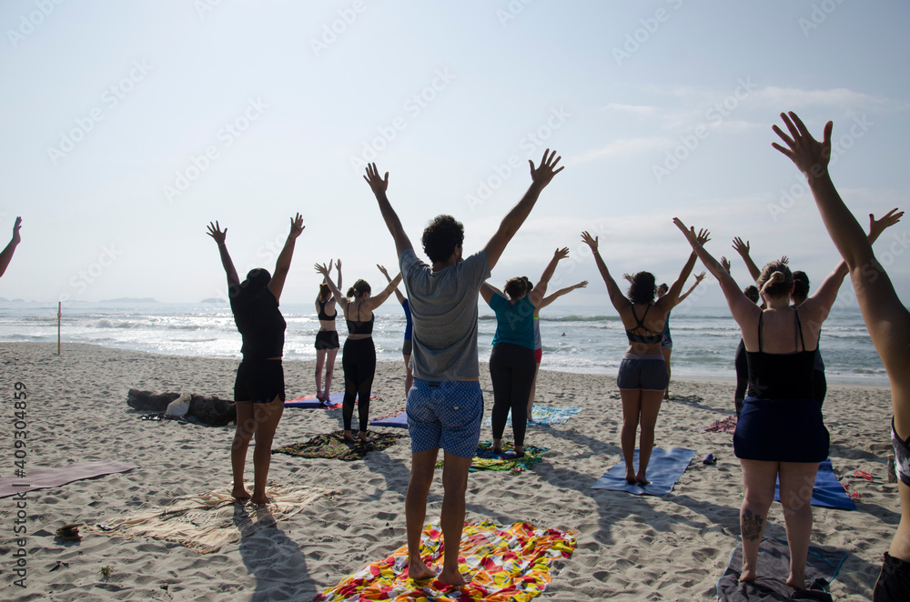 Obraz premium group of people jumping on beach, practice yoga