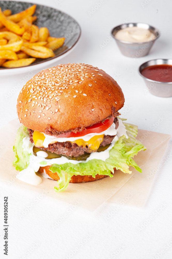 Single tasty burger with french fries and sauces Single tasty burger with french fries and sauces