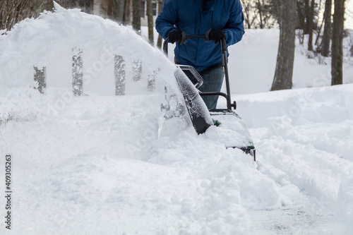 Snow blower in action clearing a residential driveway after snow storm © rabbitti