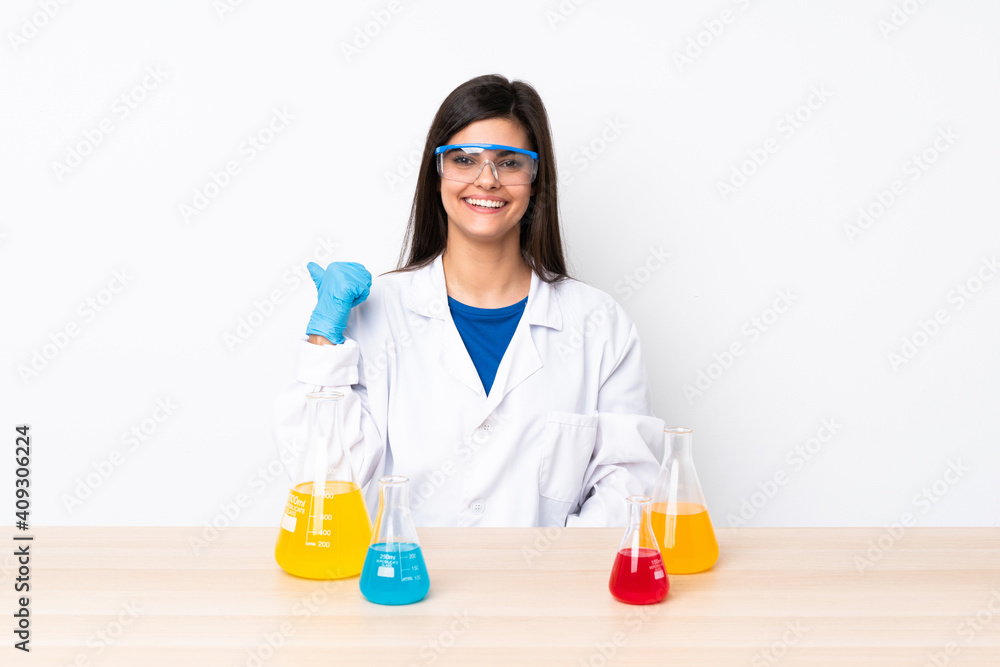 Young scientific woman in a table pointing to the side to present a product Young scientific woman in a table pointing to the side to present a product
