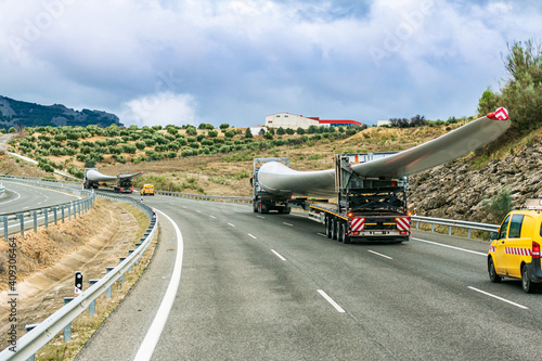 Obraz na plátně Several special transport trucks on the road transporting wind turbine blades