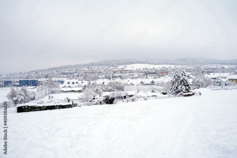 Panoramic view of village Urdorf in Switzerland in winter. It is covered with snow in extreme snowfall in January 2021.