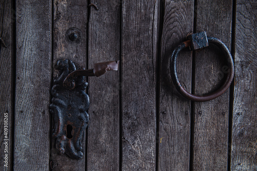 Obraz na plátně old wooden door, fragment of a vintage wooden door with an iron ring, cracks and