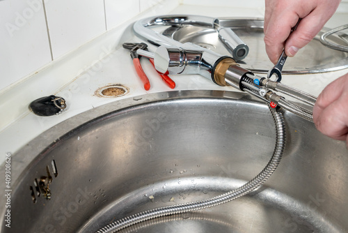 Wallpaper Mural Plumber installing a mixer tab on a sink in the kitchen Torontodigital.ca