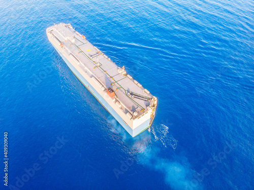 Carrier shipping out trade port blue sea. Aerial top view