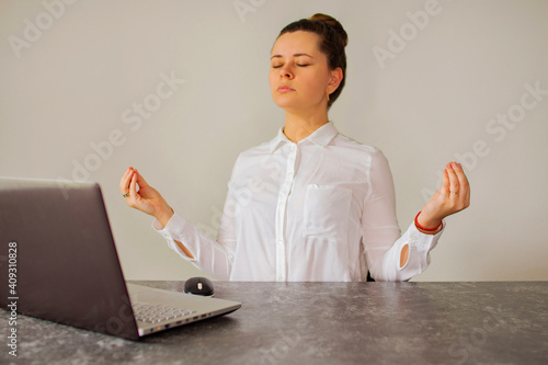 Office worker meditates in front of the computer