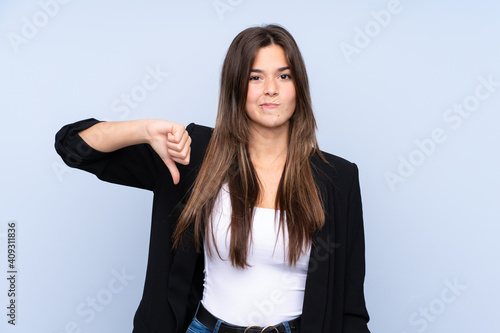 Young Brazilian business woman over isolated blue background showing thumb down sign © luismolinero