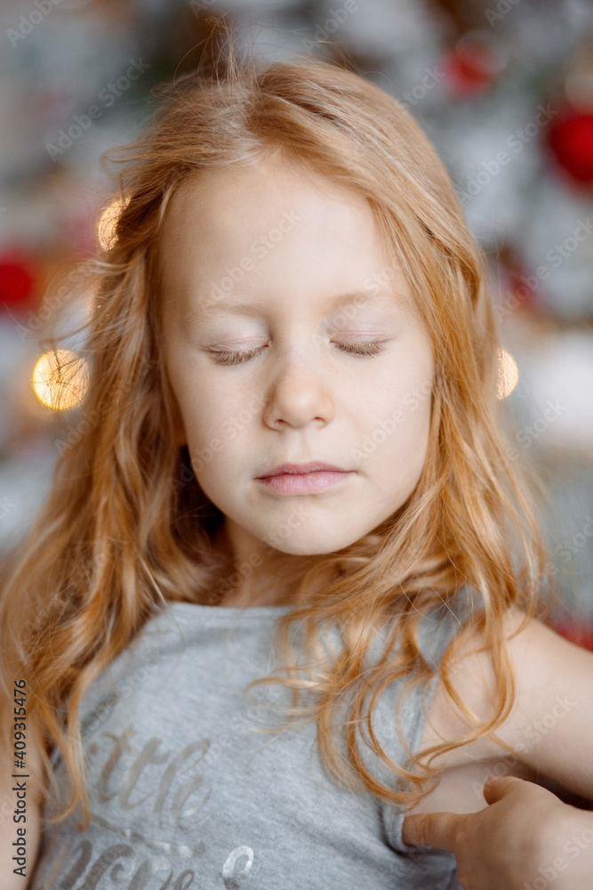 Portrait of a girl with red hair who closed her eyes. Behind her are bright lights and red balloons Portrait of a girl with red hair who closed her eyes. Behind her are bright lights and red balloons