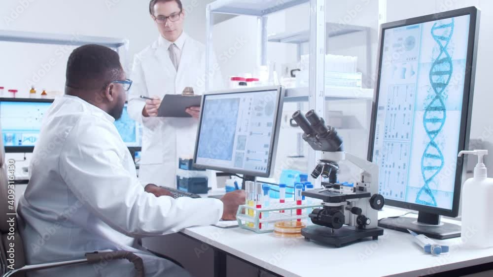 Professional African-American scientist is working on a vaccine in a modern scientific research laboratory. Genetic engineer workplace. Futuristic technology and science concept. Professional African-American scientist is working on a vaccine in a modern scientific research laboratory. Genetic engineer workplace. Futuristic technology and science concept.