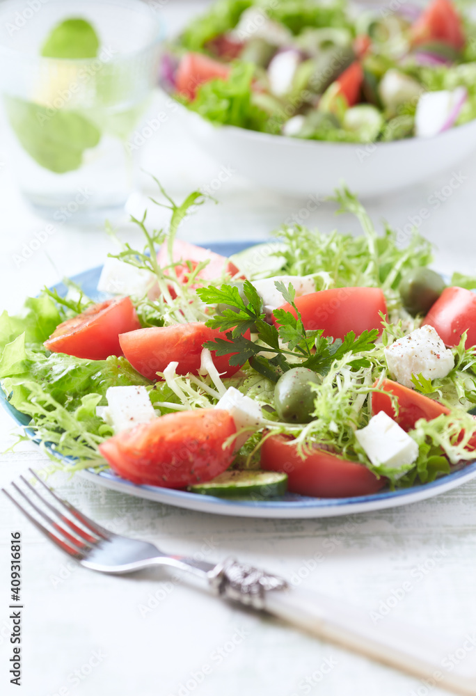 Salad with Green Olives, Tomatoes and Feta Cheese. Bright wooden background. Copy space.	
