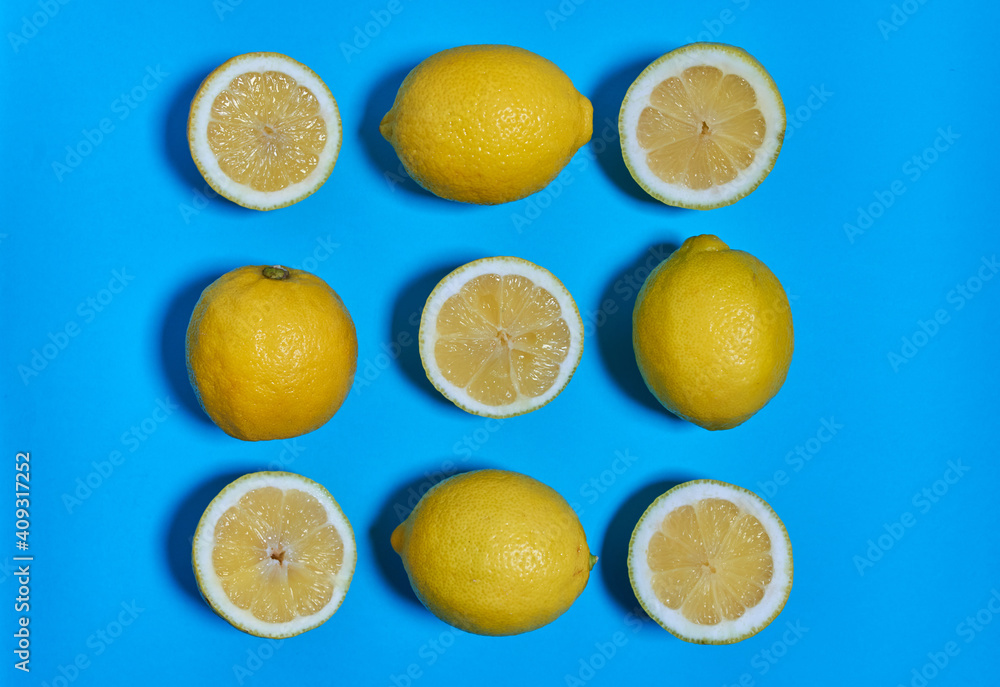Whole and split lemons on a blue background. CITRUS CITRIC