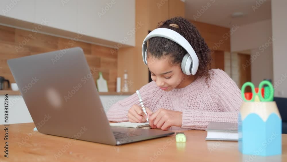Smiling teen girl watching video tutorial while sitting on isolation indoor. Smiling teen girl watching video tutorial while sitting on isolation indoor.