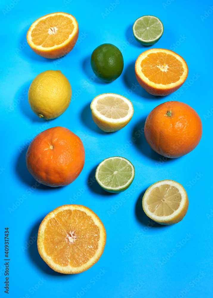 Fototapeta premium Whole and split oranges, limes and lemons with skin on a blue background. CITRUS CITRIC