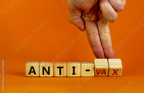 Anti-vax symbol. Doctor turns cubes with words 'anti-vax'. Beautiful orange background. Copy space. Business, medical covid-19 vaccination or anti-vax concept. photo