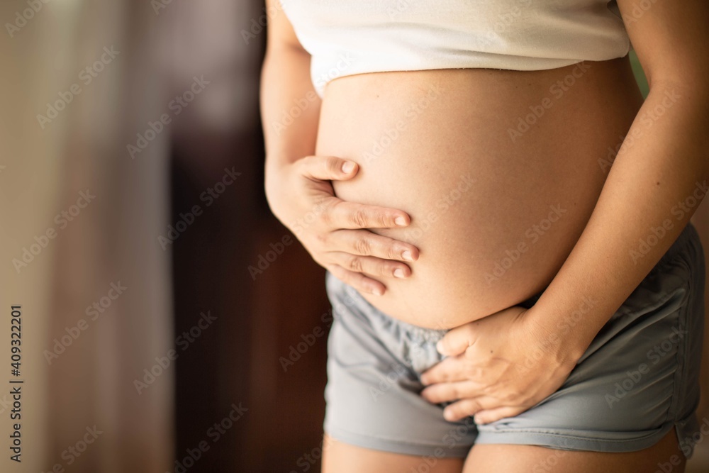 Peeing pregnant Pregnant woman holding her belly needing to pee with a week bladder. Constipation and bladder prenatal. Stock 写真 | Adobe Stock