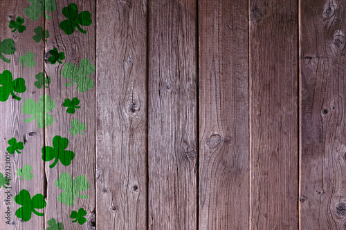 St Patricks Day shamrock side border on a rustic wood background. Copy space.