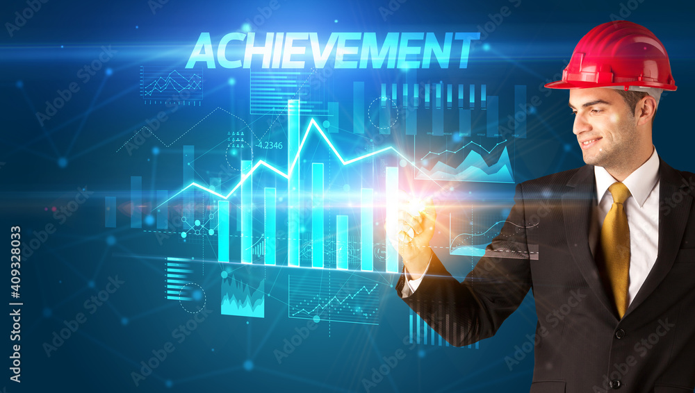 Handsome businessman with helmet drawing ACHIEVEMENT inscription, architecture business plan concept Handsome businessman with helmet drawing ACHIEVEMENT inscription, architecture business plan concept
