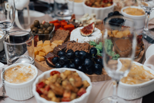 Cheese plate with chocolate, olives and grapes