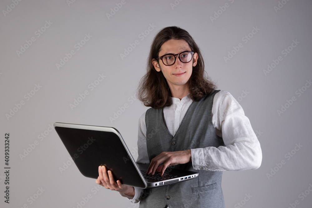 Training and new technologies, online courses, e-learning. A young man with long hair and glasses. Training and new technologies, online courses, e-learning. A young man with long hair and glasses.
